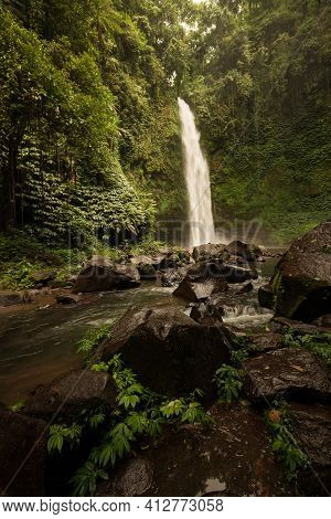 Waterfall Landscape. Beautiful Hidden Waterfall In Tropical Rainforest. Foreground With Big Stones. 