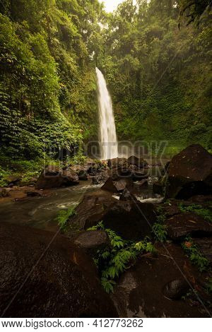 Waterfall Landscape. Beautiful Hidden Waterfall In Tropical Rainforest. Foreground With Big Stones. 