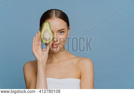 Face Care Concept. Charming Tender Woman With Combed Dark Hair Has Glowing Skin Covers Eye With Half