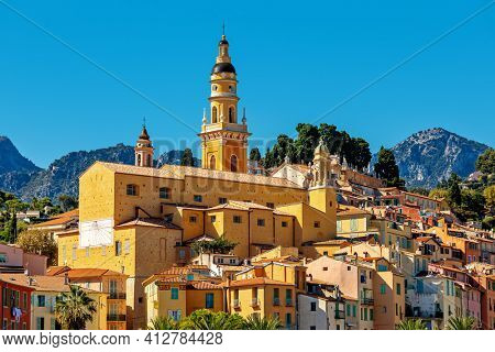 View of colorful houses and belfry of the Saint Michel Archange basilica in old town of Menton - small town on French Riviera.