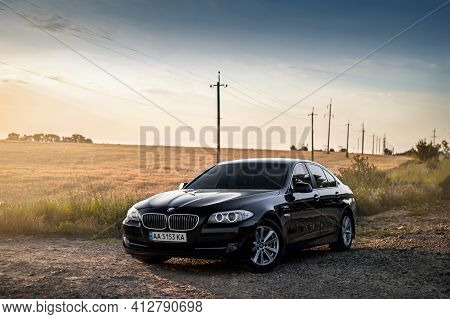 Kherson, Ukraine - June 2019. Bmw 5-series F10 In A Black Color In The Field.