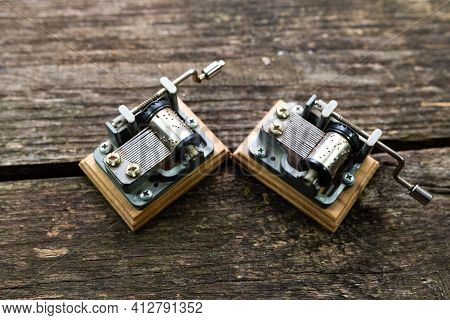 Two Vintage Mechanical Souvenir Music Box On Aged, Weathered Pine Wood Boards.