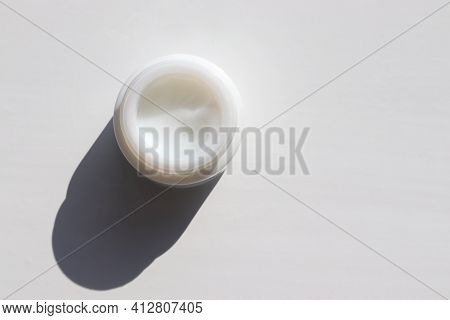 Face Cream In Glass Jar On White Table Background. Hard Light, Shadow. Natural Beauty Products For S