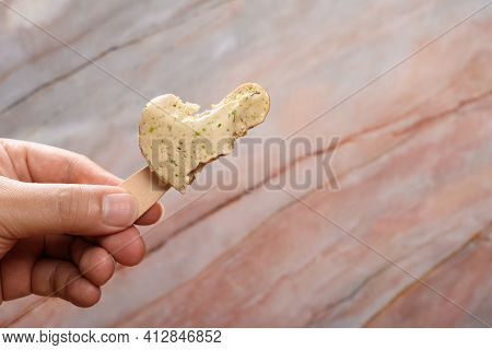 Hand Holding A Tapioca Milk Tea Flavor Popsicle With The Last Bit