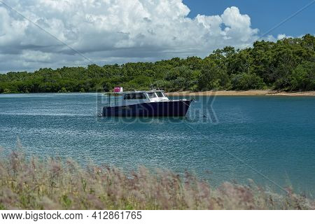 Mackay, Queensland, Australia - March 2021: A Fishing Cabin Cruiser For Sale Anchored In A Creek