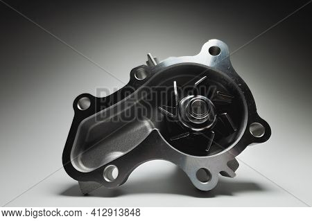 Close-up Of A New Internal Combustion Engine Cooling Water Pump On A Gray Background. Contrast Light
