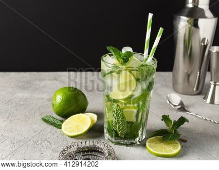 Refreshing Summer Mojito Cocktail With Ice Cubes, Fresh Mint And Lime. Ingredients And Bar Tools For