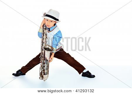 Retrato de um jazzman de menino pequeno bonito tocando seu saxofone. Isolado sobre o branco.