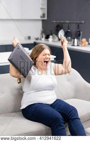 Fury, Rage, Anger With Laptop In Hand Young Overweight Girl Staying At Home During Quarantine. Self 