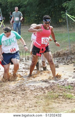 MUSKOGEE, OK - Sept. 14: Athletes run through mud and avoid zombies during the Castle Zombie Run at the Castle of Muskogee in Muskogee, OK on September 14, 2013.