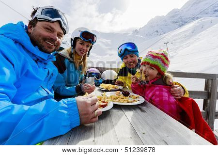 Winter, ski - skiers enjoying lunch in winter mountains
