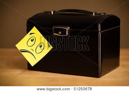 Drawn smiley face on a post-it note sticked on a jewelry box