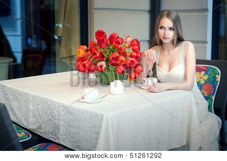 Portrait Of Young Pretty Woman Sitting In Restaurant