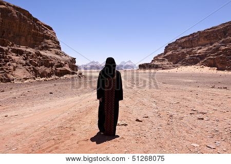 Nomadic Woman With Burka In The Desert