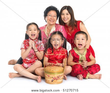 Group of happy multi generations Asian Chinese family wishing you a happy Chinese New Year, with traditional Cheongsam sitting isolated on white background.