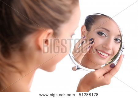 Beautiful girl preens before small mirror isolated on white