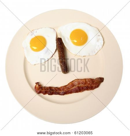 Plate with eggs, sausage, and bacon in shape of face on white background