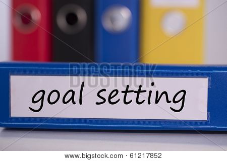 The word goal setting on blue business binder