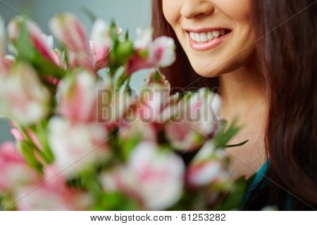Close-up of smiling female enjoying smell of flowers