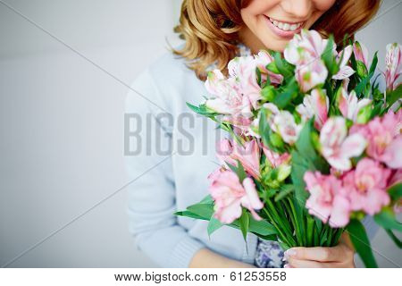 Close-up of smiling female smelling pink flowers