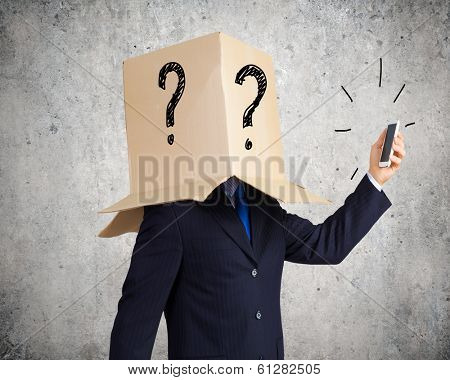 Businessman using mobile phone wearing carton box on head