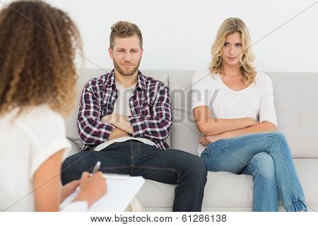 Unhappy couple not talking on the couch at therapy session