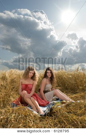 Twol chicas eslavas de picnic en el campo de trigo