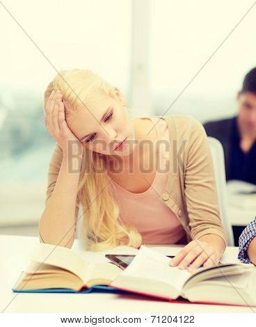 education, technology and internet concept - tired teenage girl student with tablet pc and books preparing for exam