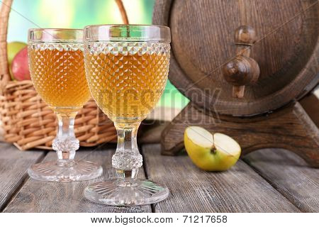 Still life with tasty apple cider and fresh apples, on nature background
