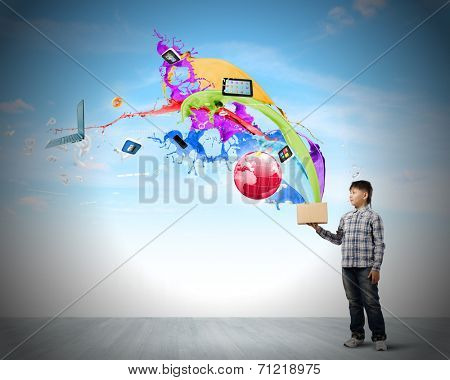 Young boy splashing colorful paint from bucket