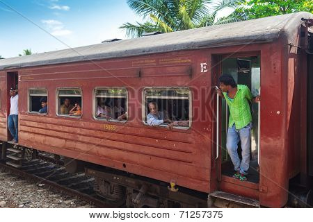 HIKKADUWA, SRI LANKA - MARCH 12, 2014: Local commuters in old train. Trains are very cheap and poorly maintained but it's the best option to witness a bit of everyday local life.