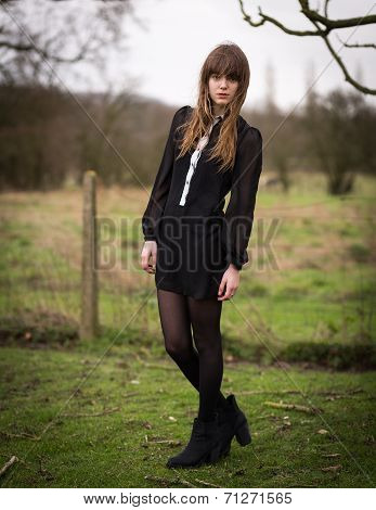 Beautiful Young Woman Dressed In Black In A Field