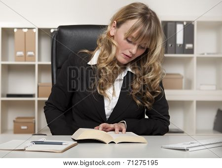 Young Businesswoman Reading A Book At Work