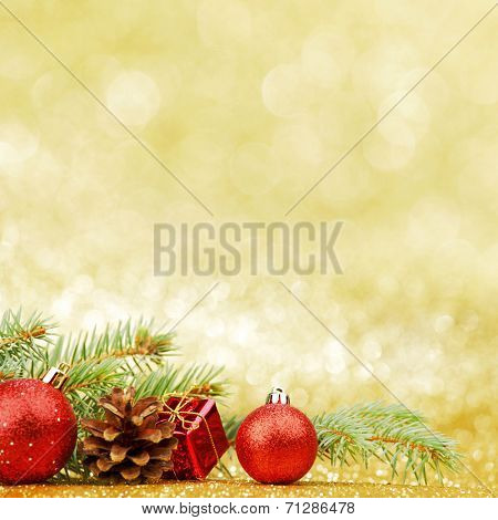 Christmas card with fir branch and decorations on golden gitter background
