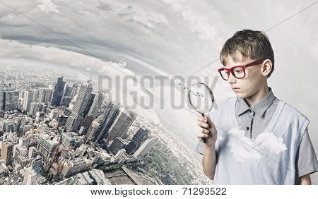 Cute school boy examining objects with magnifying glass