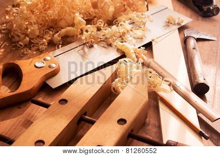 Wood working desk near the window with incandescent  lighting, Wood working tools and wood shavings. 