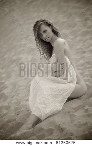 Young woman sitting on the sand