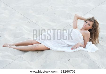 Young woman lying on the sand