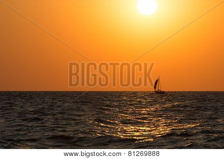 Sail Boat Is Sea Waves Against Bright Sunset Glow