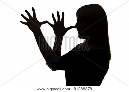 Silhouette of woman with palms on nose