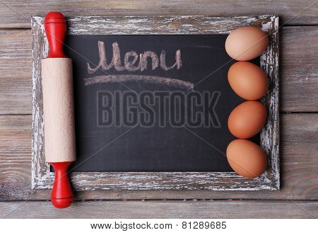 Blackboard menu on rustic wooden planks background