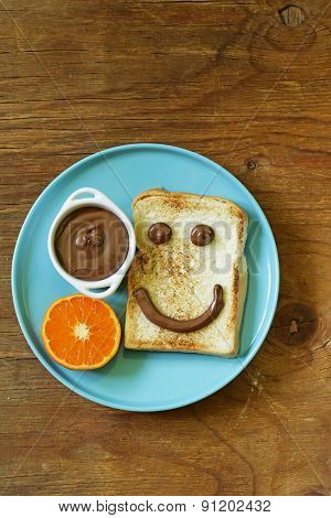 breakfast serving funny face on the plate (toast, chocolate spread)