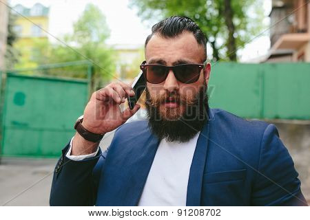 Bearded businessman looking at phone