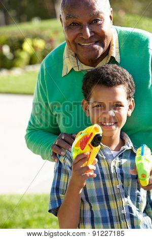 Grandfather And Grandson Shooting Water Pistols