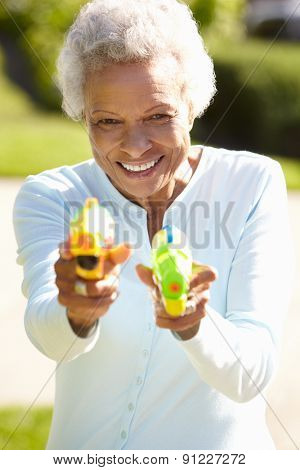 Senior Woman Shooting Water Pistols