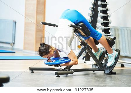 Hyperextension. fitness and sport concept. personal coach trainer woman work out at a gym with heavy weight