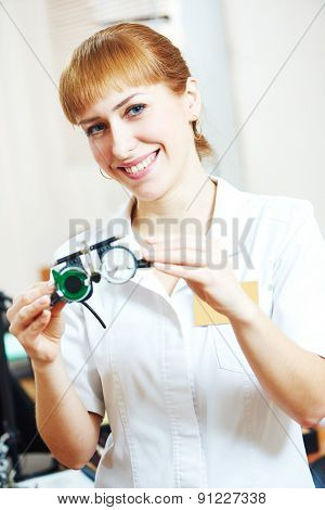 Ophthalmology. portrait of female optometrist optician doctor with test glasses phoropter in eye correction medic clinic 