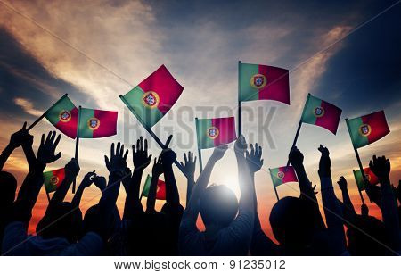 Group of People Waving Portuguese Flags in Back Lit Concept