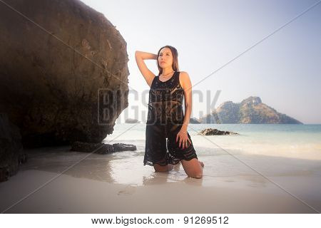 Girl In Transparent Dress On Knees On Sand