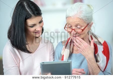 Helping old woman use a tablet computer